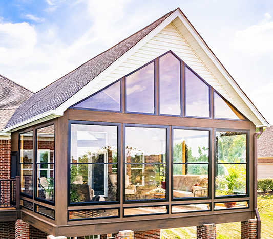 The exterior of a vinyl pane sunroom with an a-frame roofline